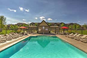Cheney apartment for rent - A resort style pool with chaise lounge chairs and umbrellas