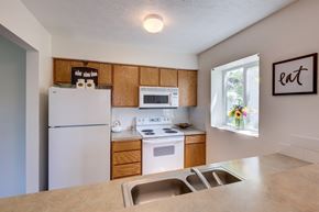 Spokane apartment for rent - a kitchen with white appliances and wooden cabinets