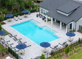 Jacksonville apartment for rent - A large swimming pool surrounded by lounge chairs and umbrellas.