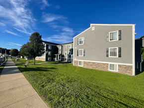New London apartment for rent - an apartment building with a green lawn and a sidewalk