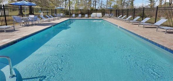 Jacksonville apartment for rent - a large swimming pool with chairs and umbrellas