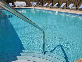 Jacksonville apartment for rent - a large swimming pool with a railing and chairs in it