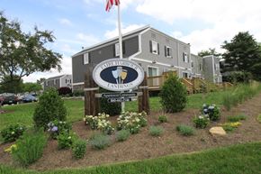 New London apartment for rent - the sign in front of an apartment building with a flag and flowers
