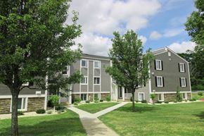 New London apartment for rent - an apartment complex with trees and a sidewalk