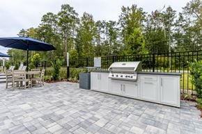 Jacksonville apartment for rent - A patio with a grill and chairs.