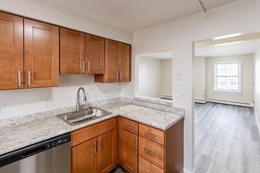 Middletown apartment for rent - A kitchen with wooden cabinets and a marble countertop.