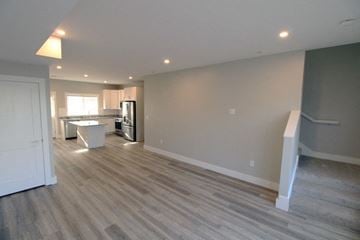 Middletown apartment for rent - A room with a kitchen area in the background and a dining table in the foreground.
