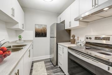 London apartment for rent - a kitchen with stainless steel appliances and white cabinets