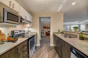 London apartment for rent - a kitchen with white cabinets and a wooden floor