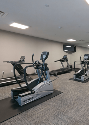 London apartment for rent - a gym with cardio equipment and a tv in a room