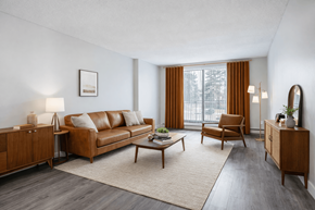 London apartment for rent - A living room with a brown leather sofa, a wooden coffee table, and a large window with orange curtains.