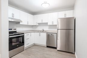 London apartment for rent - A modern kitchen with stainless steel appliances and white cabinets.