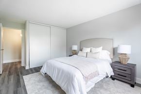 London apartment for rent - A bedroom with a large bed and a nightstand with a lamp  at Platts Crossing, London, ON, N6H 4P4