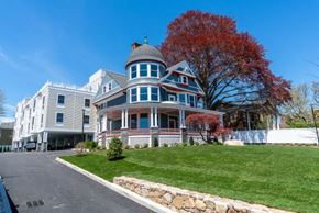 Norwalk apartment for rent - a large house on a hill with a tree in the background