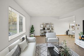 Fairview Heights apartment for rent - A living room with a white sofa, a chair, a coffee table, and a bookshelf.