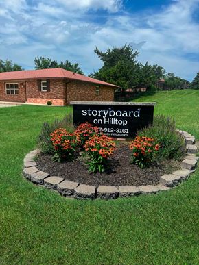 Columbia triplex for rent - A sign for Storyboard on Hilltop stands in a flowerbed.