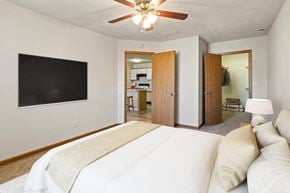 Shiloh apartment for rent - A bedroom with a large bed and a flat screen TV on the wall.