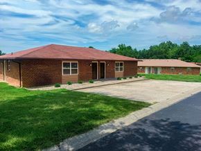 Columbia triplex for rent - A red brick building with a green lawn in front.