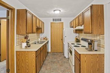 Fairview Heights apartment for rent - A kitchen with wooden cabinets and a white refrigerator.