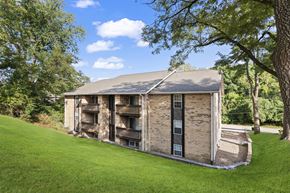 Edwardsville apartment for rent - a small brick building with a porch on a grassy field