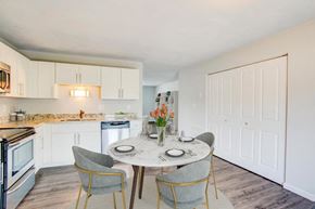 O'fallon apartment for rent - a dining area with a table and chairs and a kitchen in the background
