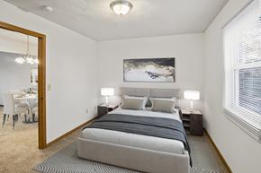Fairview Heights apartment for rent - A bedroom with a large bed and a painting on the wall.