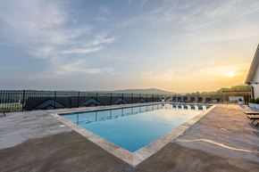 Barnhart apartment for rent - A large outdoor swimming pool with a sunset in the background.