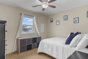 Columbia triplex for rent - A bedroom with a bed, a window with curtains, and a ceiling fan.