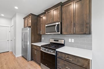 Vancouver house for rent - A kitchen with wooden cabinets and a stainless steel refrigerator.