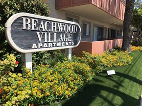 Huntington Beach apartment for rent - a sign apartments in front of flowers