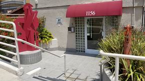 West Hollywood apartment for rent - A red sculpture in front of the leasing building and the number 1156.