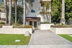 Los Angeles apartment for rent - the sidewalk in front of a building with palm trees