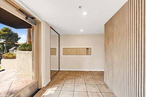 Los Angeles apartment for rent - A hallway with a tan wall with mailboxes and a tan tile floor.