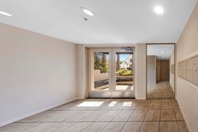 Los Angeles apartment for rent - A hallway with a tiled floor and a large mirror on the wall.