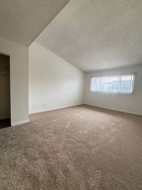 Torrance apartment for rent - an empty living room with carpet and a window