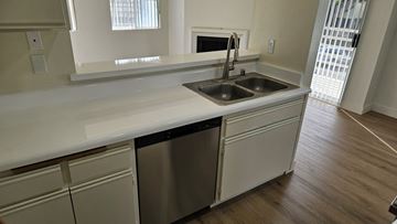 West Hollywood apartment for rent - A kitchen with a white counter top and a stainless steel dishwasher.
