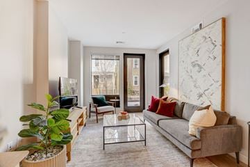 Dorchester apartment for rent - A living room with a grey couch, a coffee table, and a large painting on the wall.