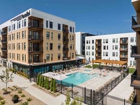 Omaha apartment for rent - A large apartment complex with a pool in the middle of the courtyard.