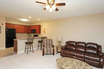 Elkhorn apartment for rent - A living room with a brown leather couch and a bar area.