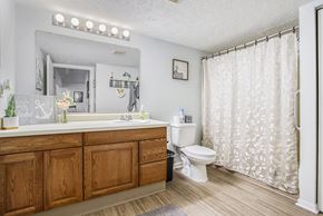 Battle Creek apartment for rent - A bathroom with a wooden vanity and a white toilet.
