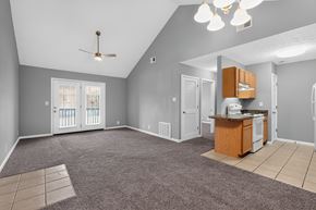 Shelbyville apartment for rent - A spacious living room with a kitchenette and a ceiling fan.
