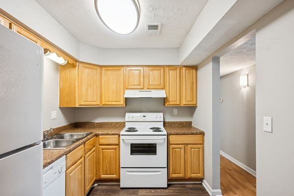 Louisville apartment for rent - A kitchen with wooden cabinets and a white stove top oven.