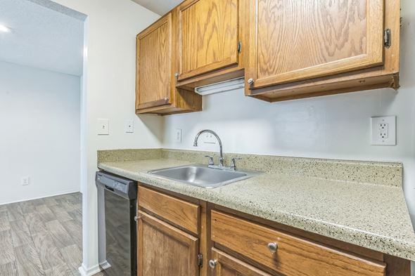 Mobile apartment for rent - Kitchen with wood cabinets and granite counters at Ashford Place Mobile AL