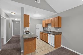 Shelbyville apartment for rent - A kitchen with a white dishwasher and wooden cabinets.