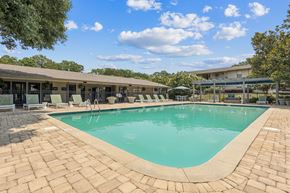 Mobile apartment for rent - A large outdoor swimming pool surrounded by a brick patio.