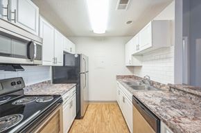 Fenton apartment for rent - A kitchen with black appliances and white cabinets.