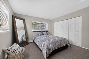 Carol Stream apartment for rent - Bedroom at Renaissance at Carol Stream featuring a large bed and wall mirror in Carol Stream, IL.