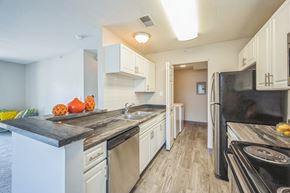 Fenton apartment for rent - A kitchen with black appliances and white cabinets.