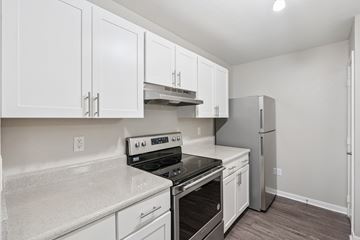West Des Moines apartment for rent - A kitchen with white cabinets and a stove top oven.