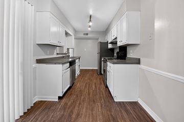 Jackson apartment for rent - A kitchen with white cabinets and a wooden floor.